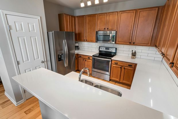 A kitchen with stainless steel appliances and wooden cabinets.