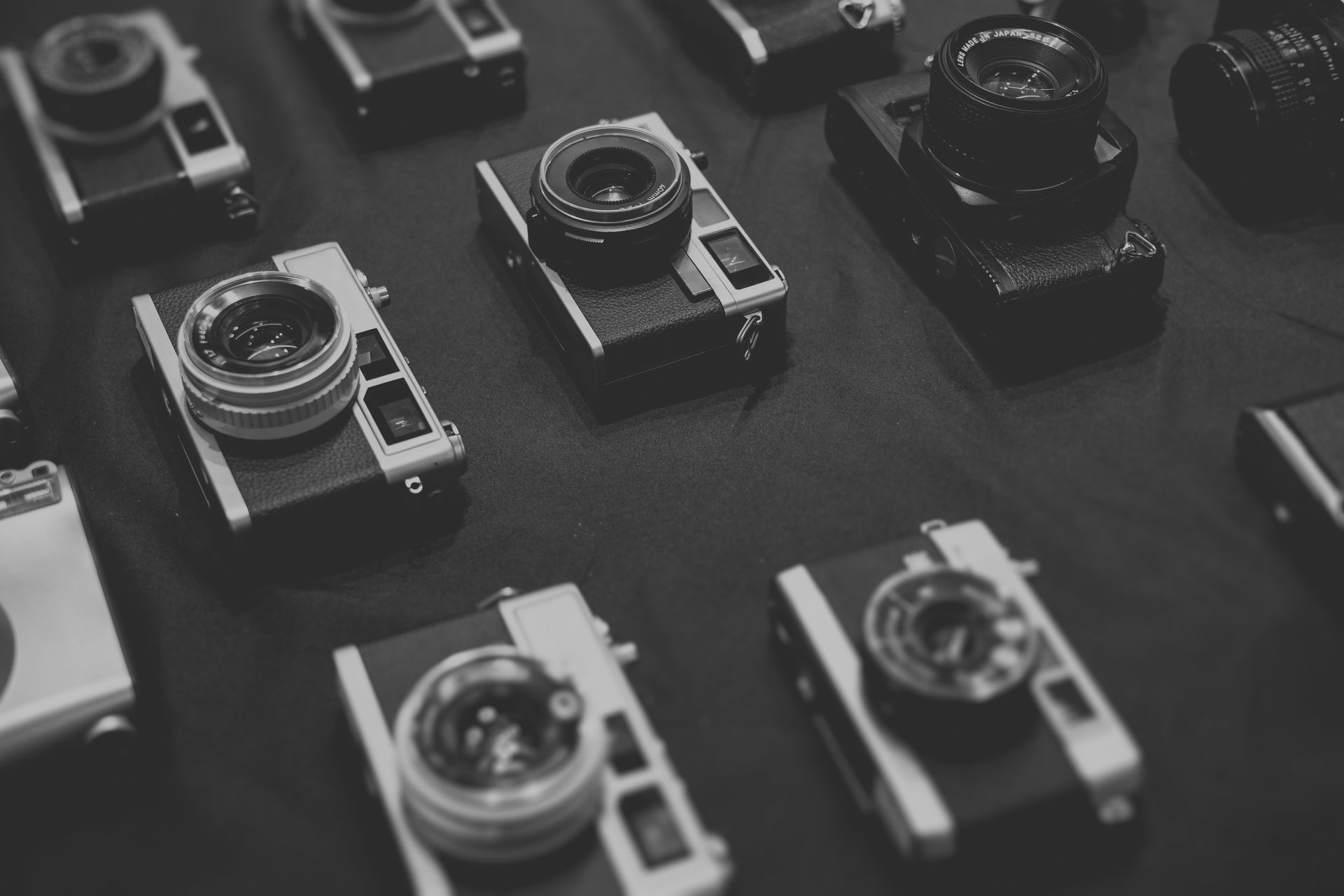 一組黑白老式相機，擺在桌面上。