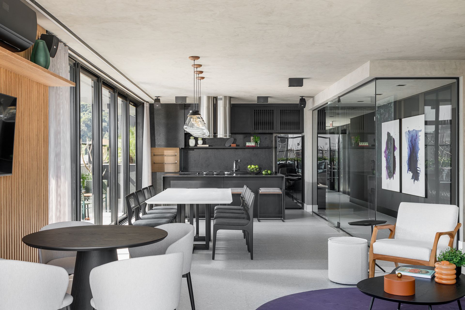 Sala de estar moderna em plano aberto com cozinha, área de jantar e assentos; cores cinza escuro e branco.