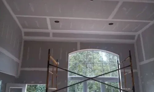 A room with a window and a scaffolding in it.