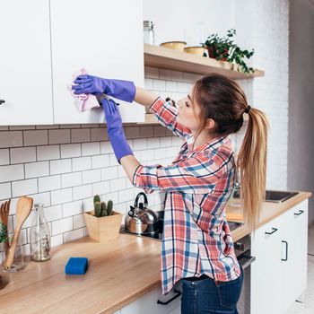 Housekeeping Services — Woman Cleaning The Cabinets in Florence, SC