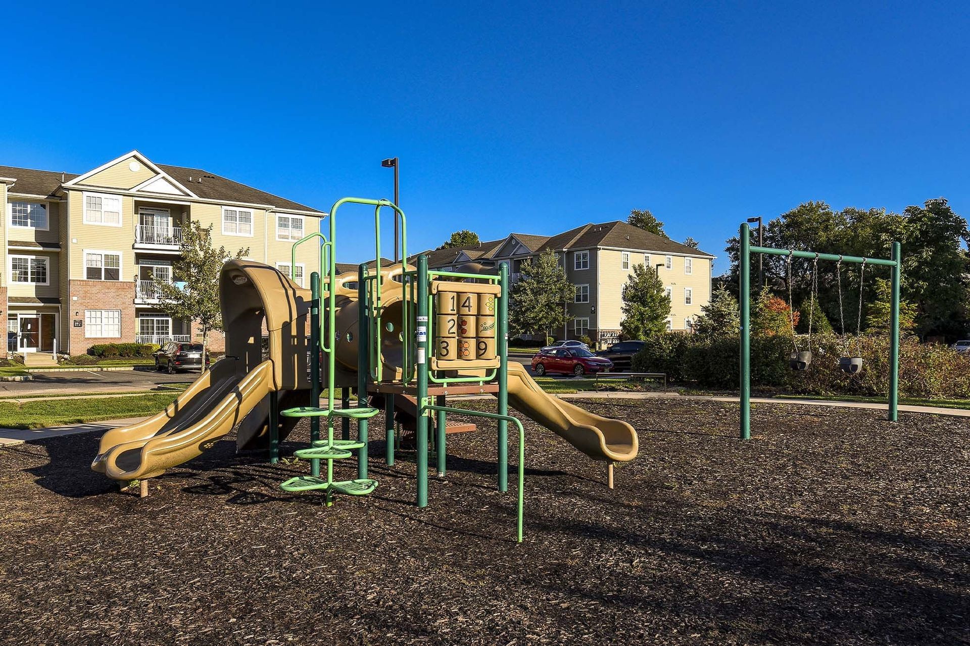 Playground with slides and climbing equipment in a residential apartment complex.