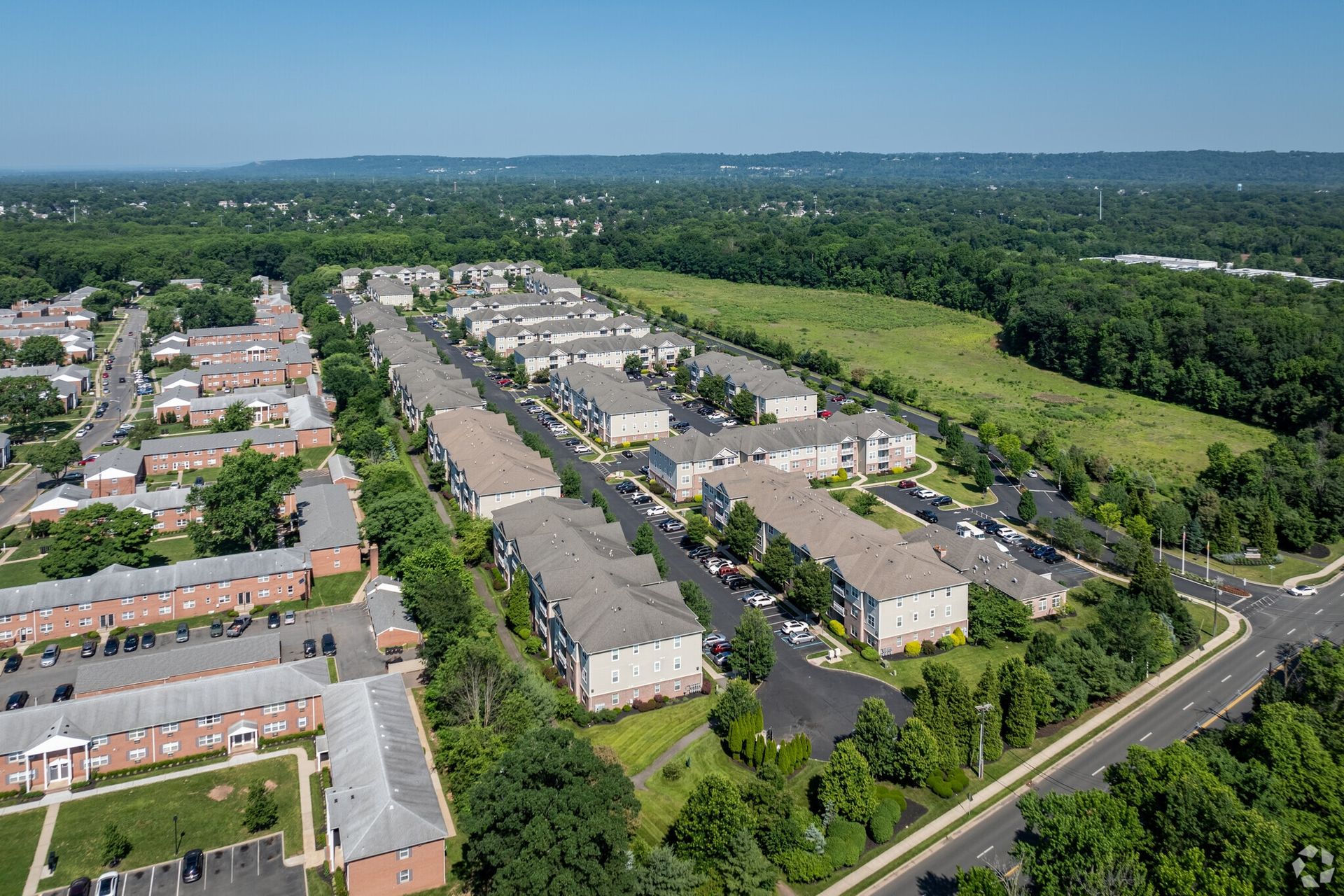 Aerial view of a large apartment community with rows of buildings, parking lots, and green space.