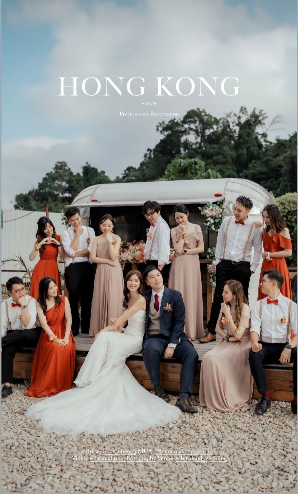 Wedding party in Hong Kong posing outdoors by a trailer, bride and groom in the center, bridesmaids in pink, groomsmen in white.