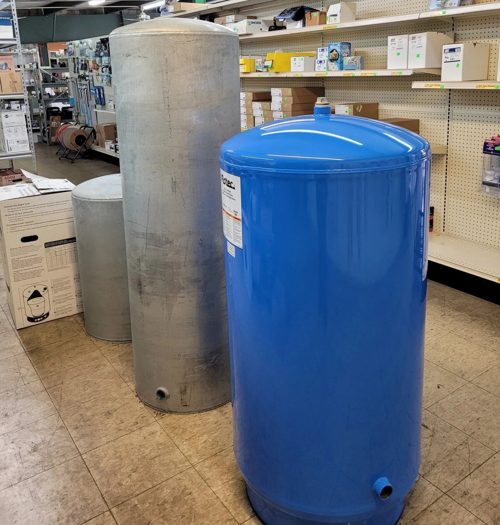 Blue Tank is Sitting Next to a Silver Tank — Hattiesburg, MS — McElhaney Plumbing & Hardware Inc