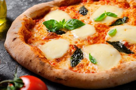 Pizza Margherita con mozzarella fusa, foglie di basilico e salsa di pomodoro su una superficie scura