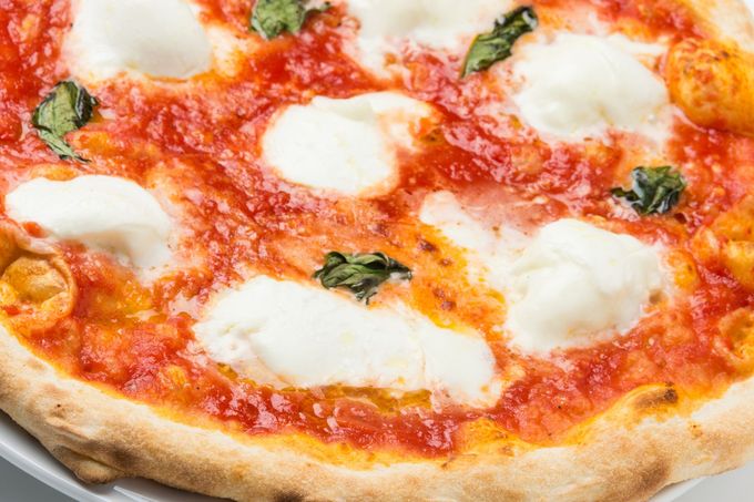 Pizza Margherita con mozzarella fusa, salsa di pomodoro e basilico su una crosta dorata