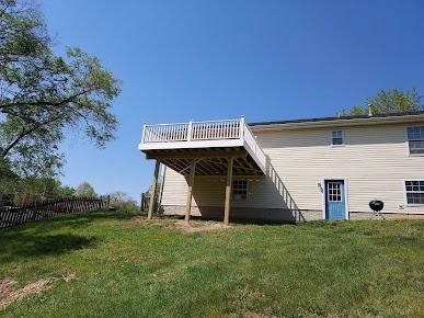 The back of a house with a large deck and stairs.