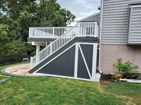 A house with a deck and stairs in the backyard.
