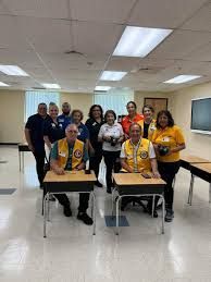 A group of people are sitting at desks in a room.