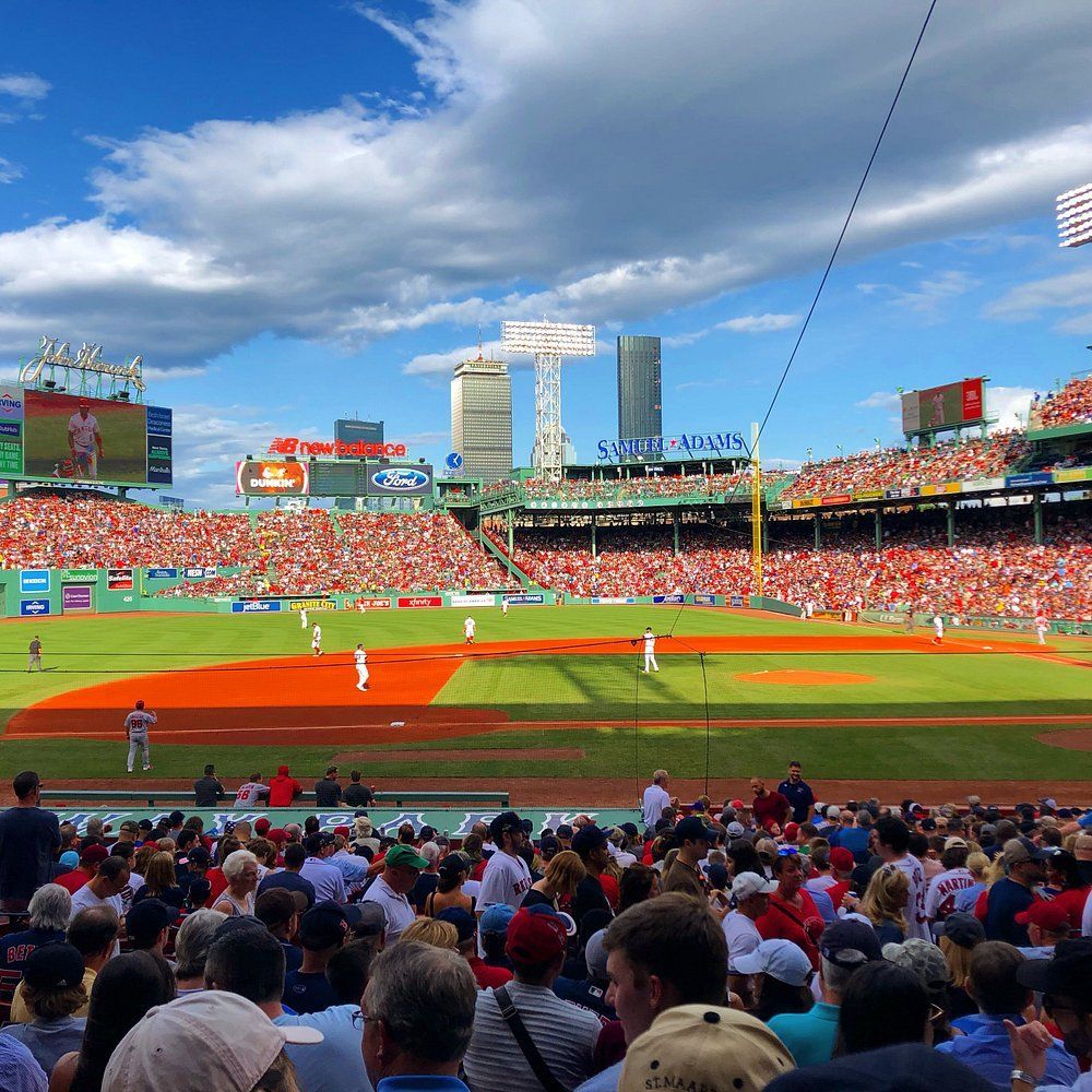 A crowd of people are watching a baseball game at a stadium