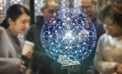 People looking at a glowing, network-like sphere held on a phone.