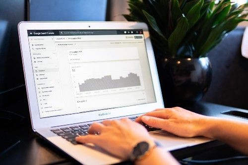 Une personne tape sur un ordinateur portable avec un graphique à l'écran.