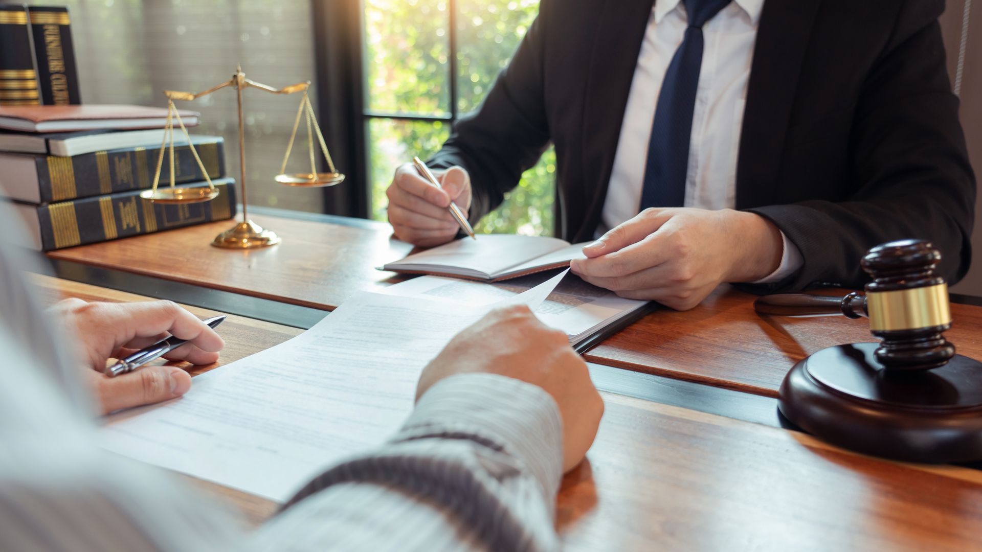 A lawyer is sitting at a desk talking to a client.