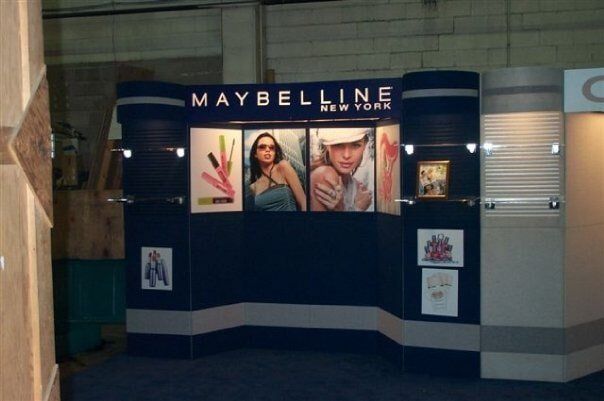 Maybelline storefront display with cosmetics posters and dark blue walls in a mall corridor