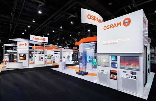 OSRAM trade show booth with orange and white displays and signage, showcasing lighting products.