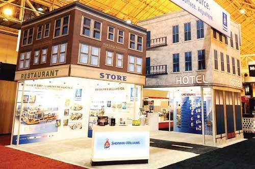Booth designed as city buildings; a restaurant, store, and hotel.