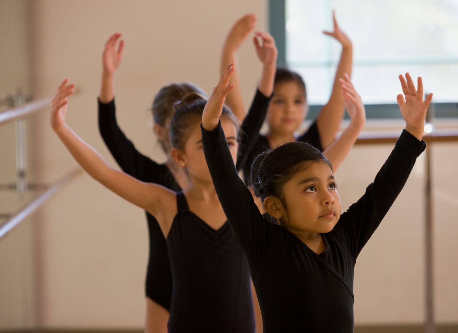 Un gruppo di giovani ragazze si esercita nel balletto in una scuola di danza.