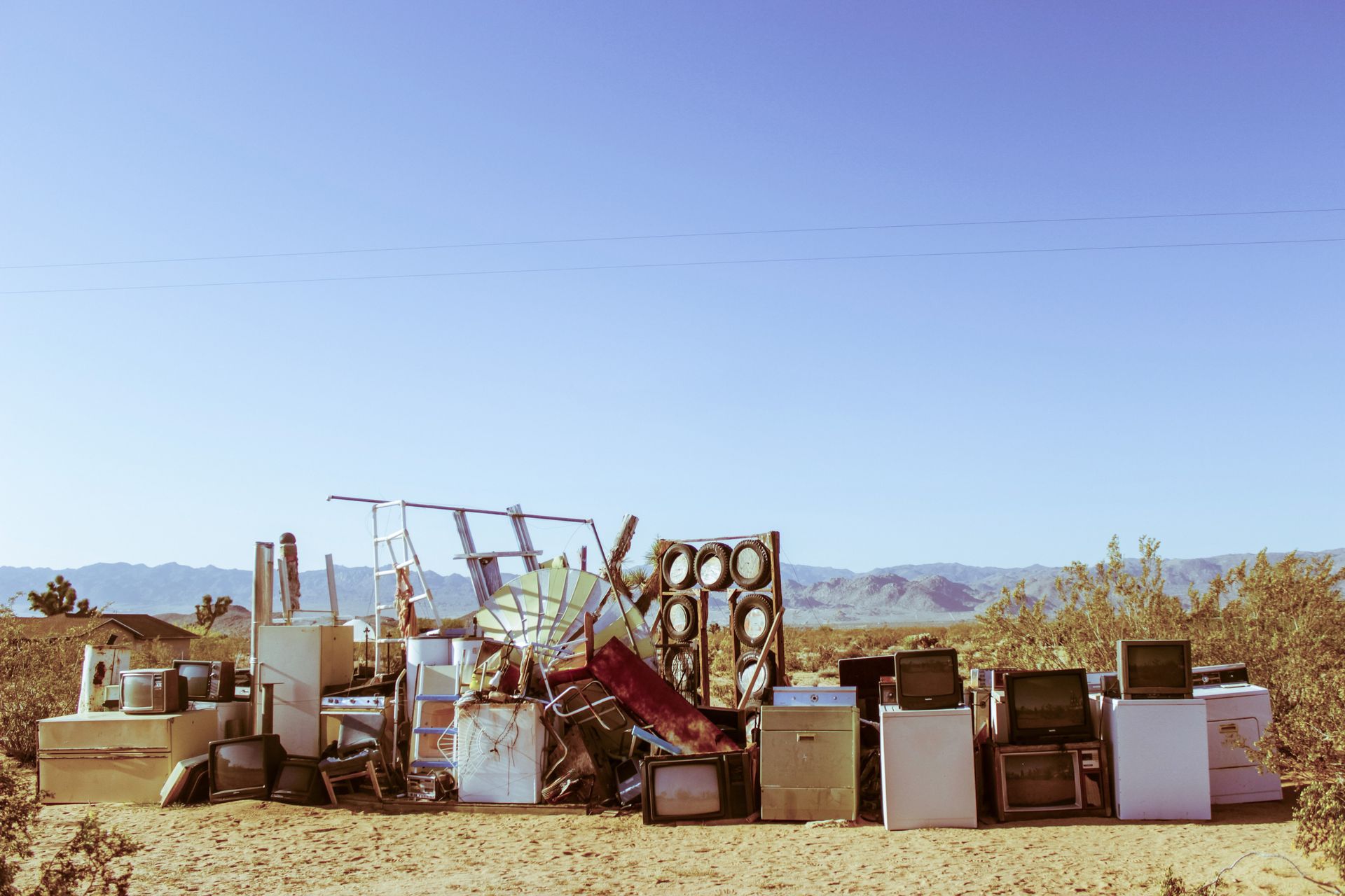 A pile of old TV's is sitting in the middle of a field.