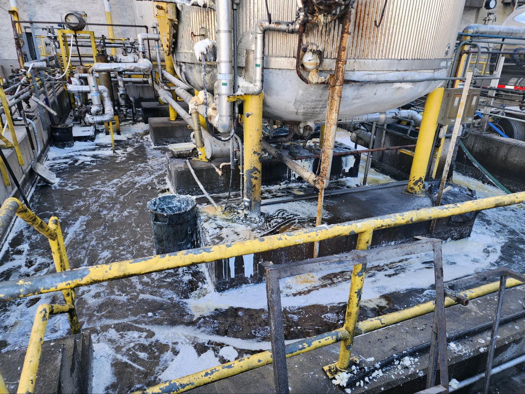 Industrial equipment on a platform covered in white foam. Yellow railings and pipes are visible.