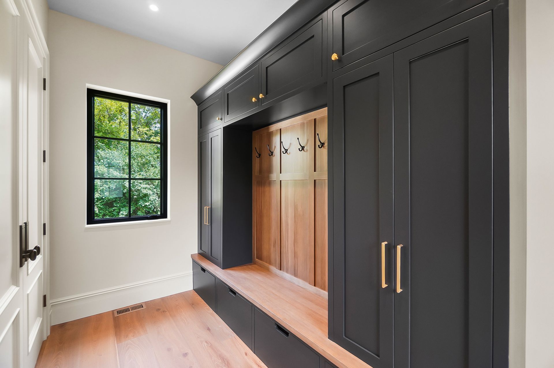 A bedroom with a bed , ceiling fan , and hardwood floors.