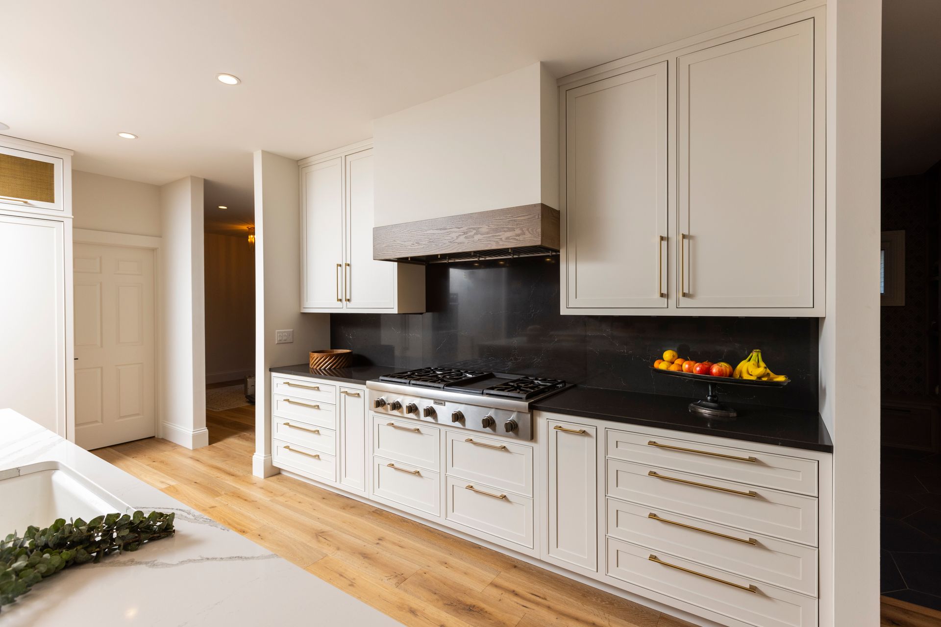 A kitchen with a stove top oven and a herringbone tile backsplash.