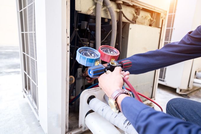 A man is working on an air conditioner.