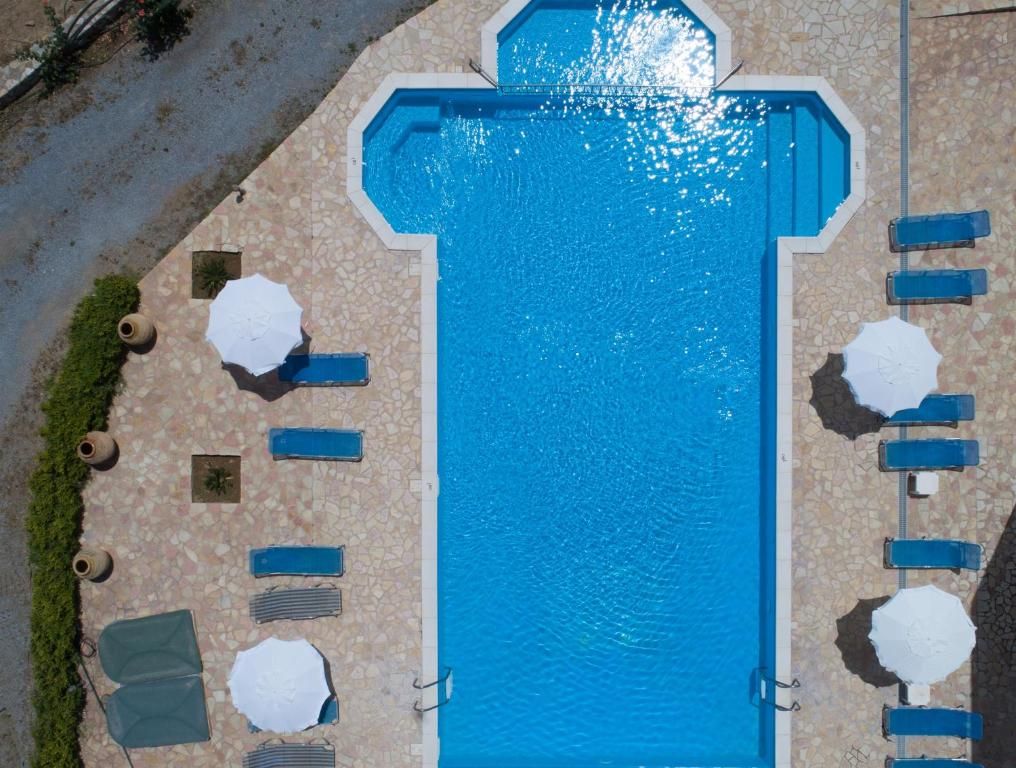 White buildings with blue accents cascade down a hillside overlooking a blue sea and sky, Santorini, Greece.