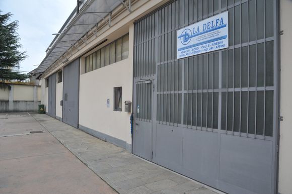 Foto in prospettiva del cancello ferrato d'ingresso al magazzino La Delfa