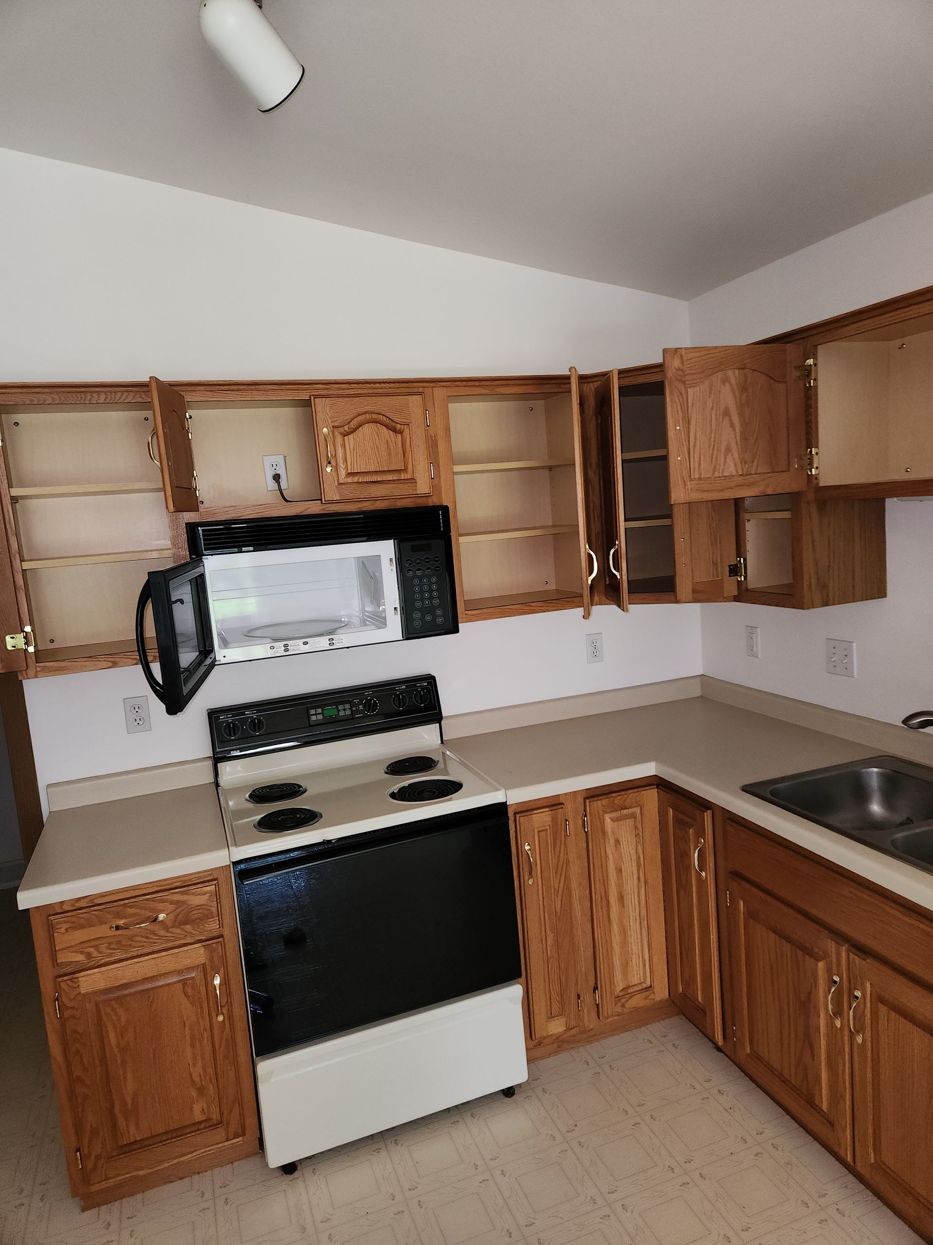 A kitchen with wooden cabinets and a black stove top oven
