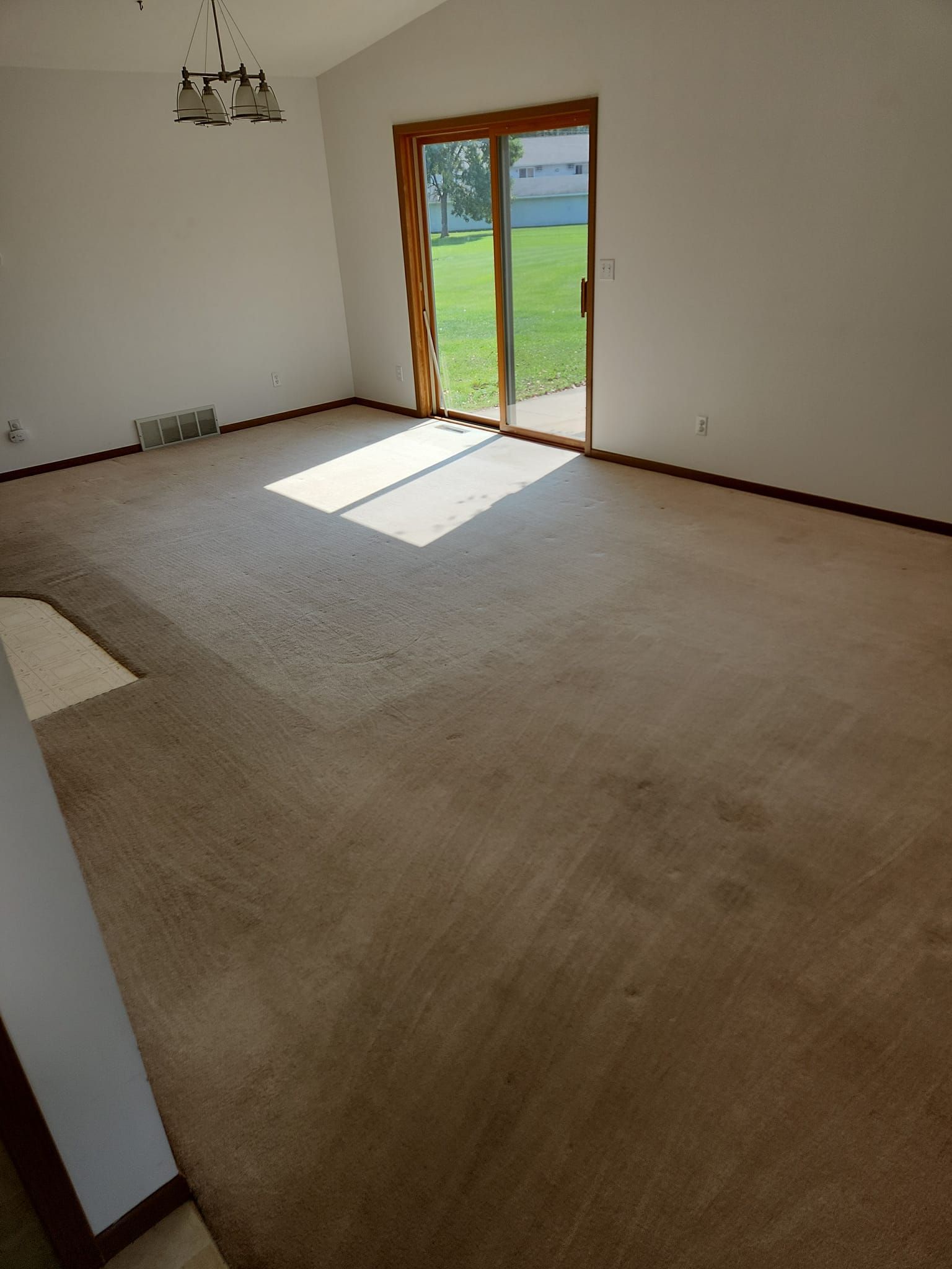 An empty living room with a sliding glass door