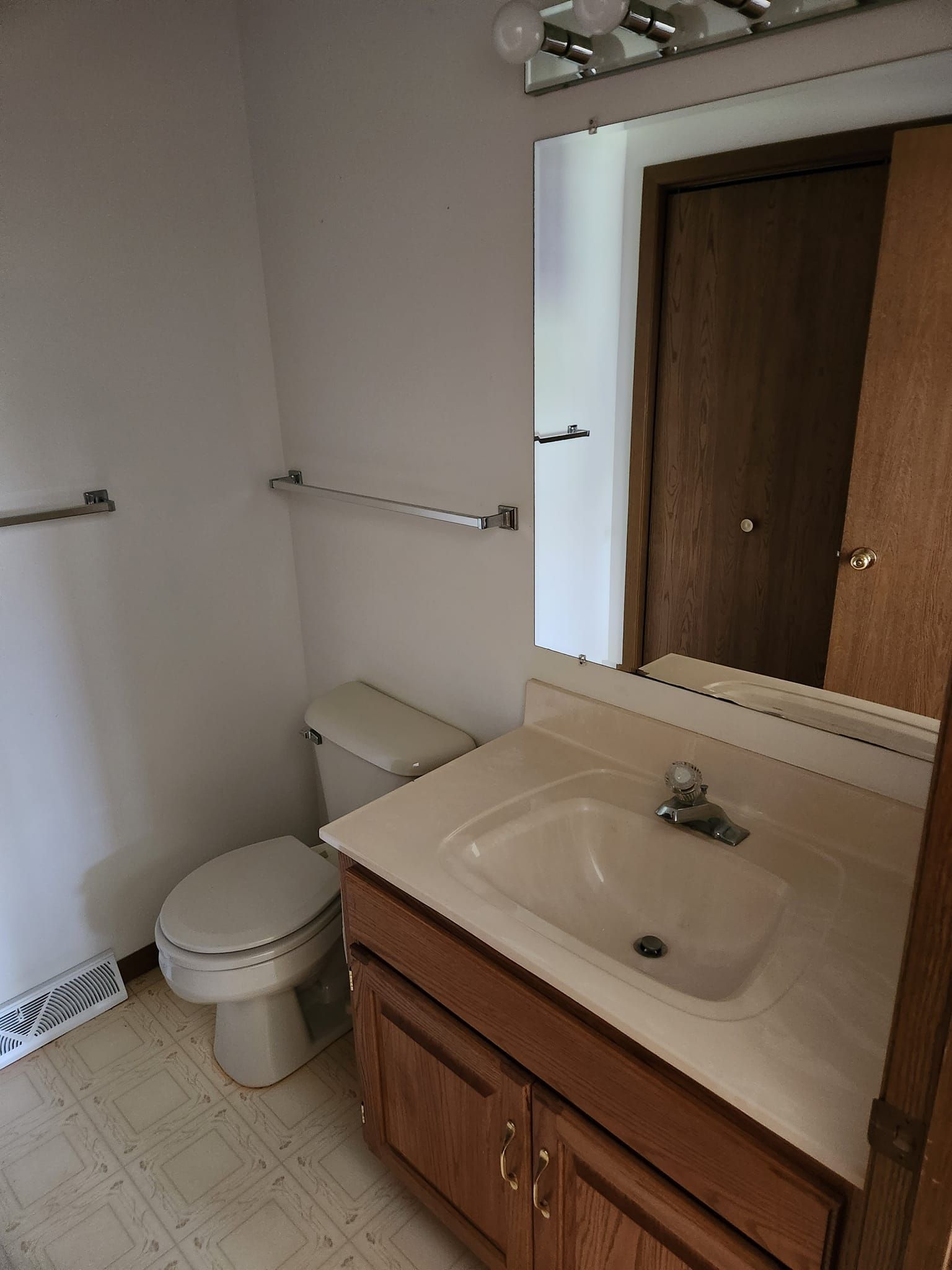 A bathroom with a sink toilet and mirror