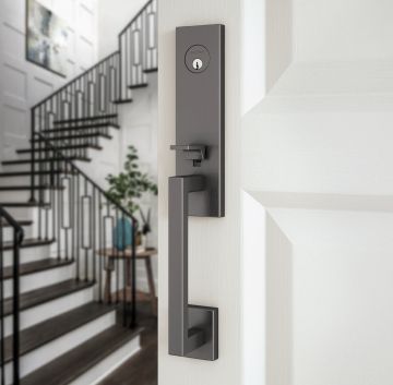 Dark gray door handle on a white door, with a staircase in the background. Dark gray door handle on a white door, with a staircase in the background.