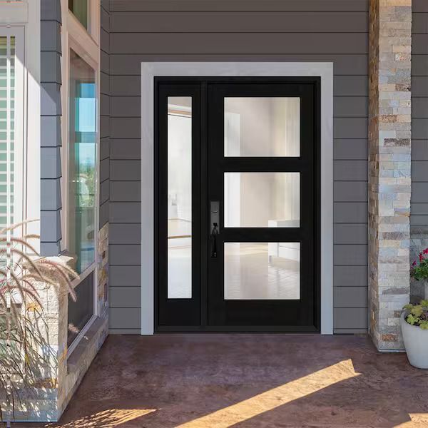 Black front door with sidelight and three rectangular glass panels set in a gray exterior. Black front door with sidelight and three rectangular glass panels set in a gray exterior.