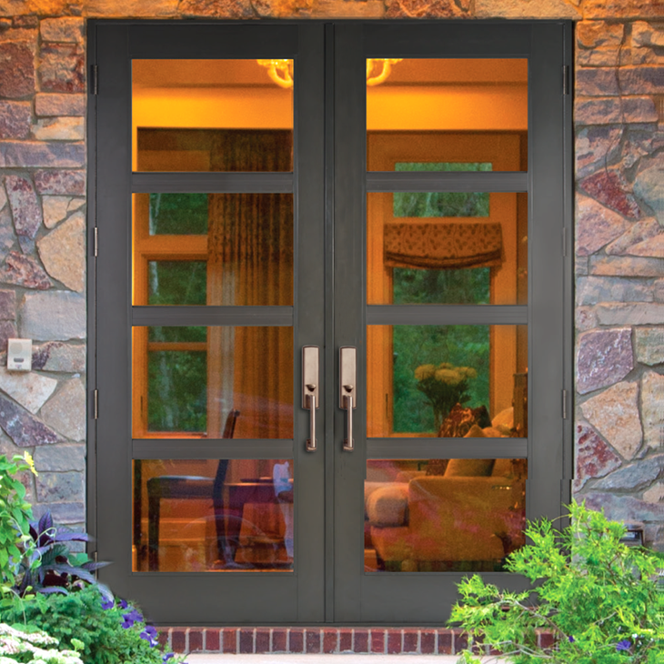 Double black doors with rectangular glass panes, set in a stone wall, leading inside; interior visible.