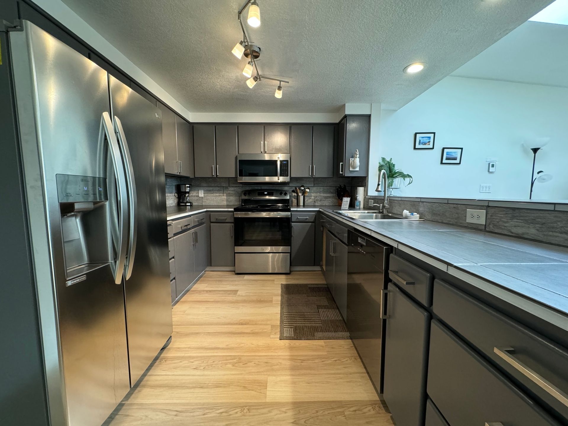 A kitchen with stainless steel appliances and gray cabinets