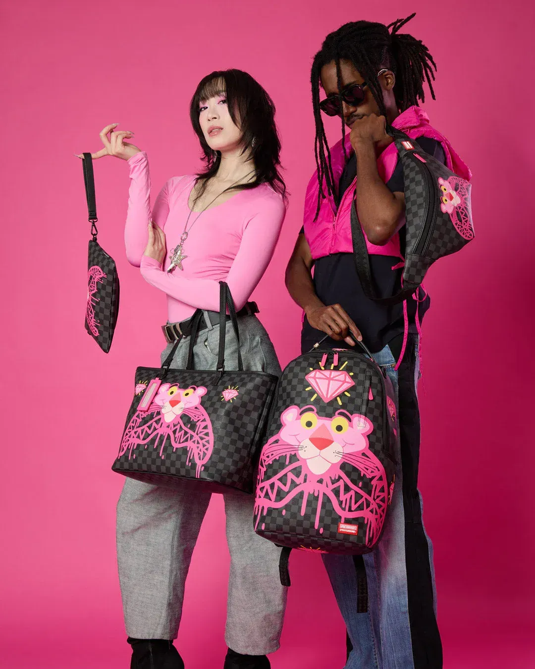 Due modelle in posa con borse nere e rosa su uno sfondo rosa acceso