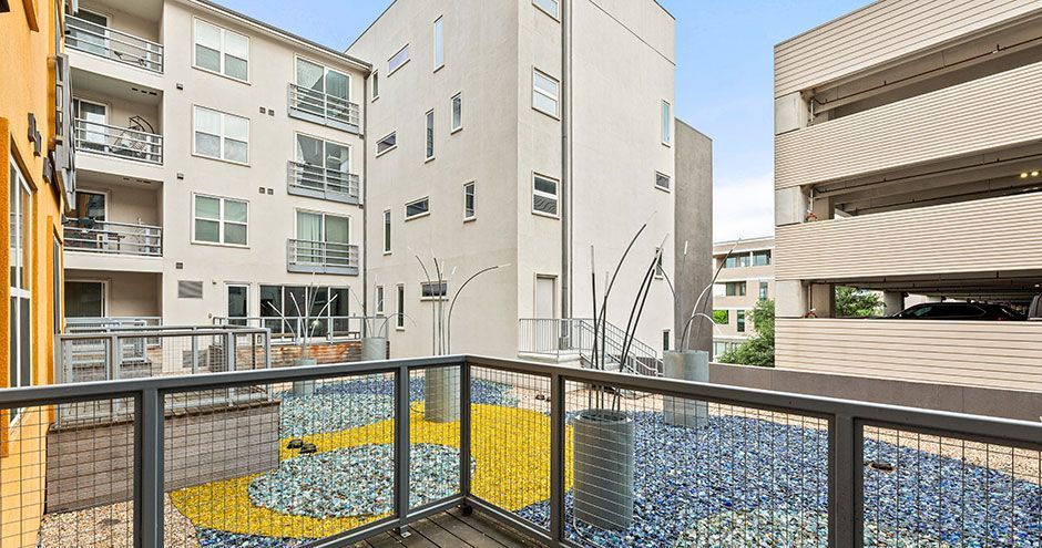 View from balcony overlooking a courtyard with blue, yellow mosaic at The Standard at Domain NORTHSIDE, offers luxury apartments with balcony or patrio in North Austin.