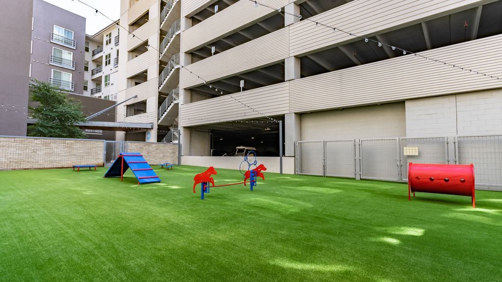 Dog park at The Standard at Domain, offers apartments by The Domain Austin, next to the parking deck.