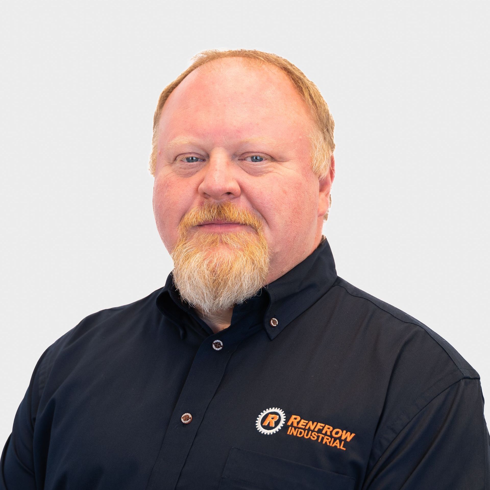 Man with a beard in a black Renfrew Industrial shirt against a white background.