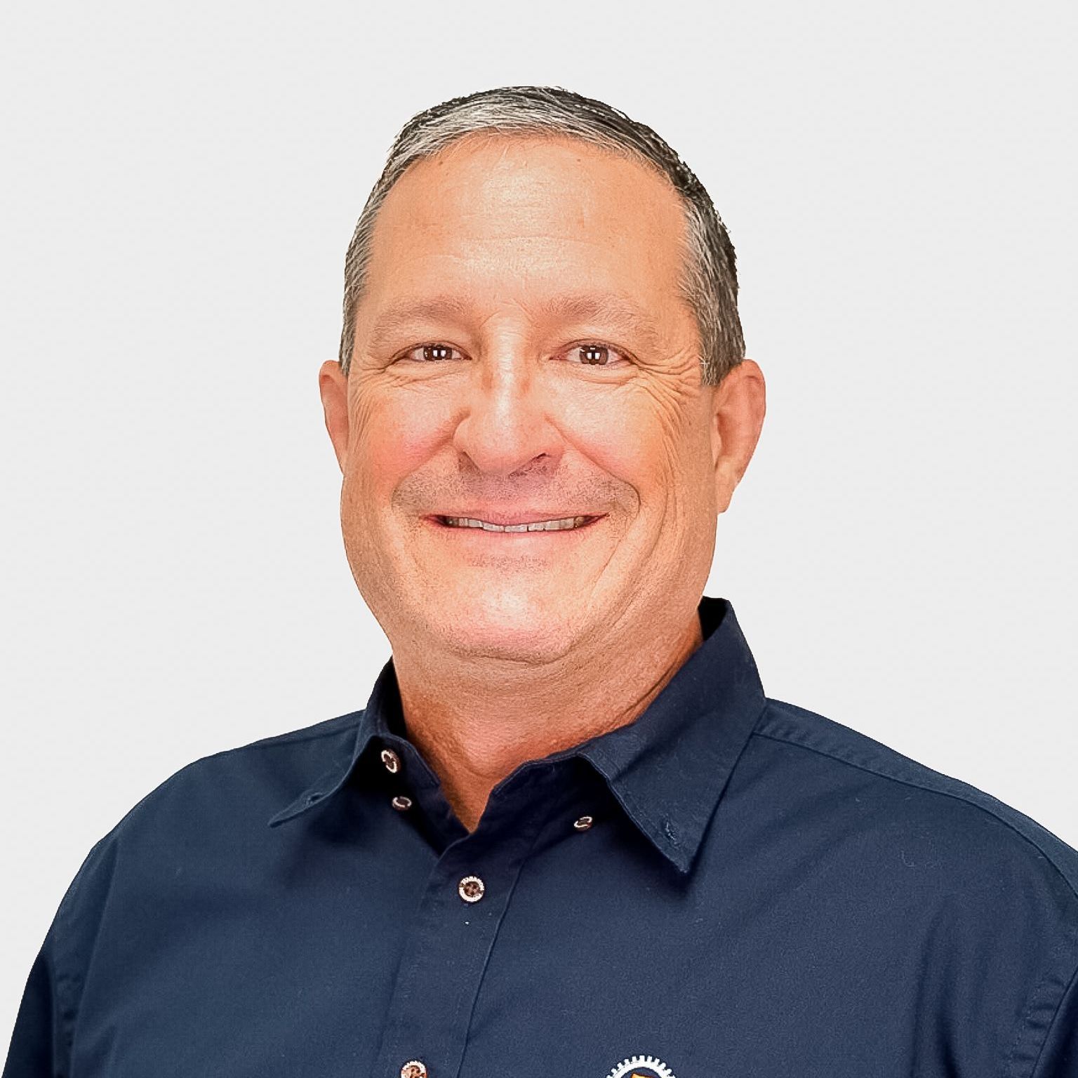 Smiling middle-aged man in a navy blue shirt against a white background.