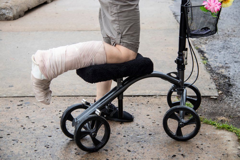 A Person with A Cast on Their Leg Is Sitting on A Knee Walker — Toukley World of Bikes In Toukley, NSW