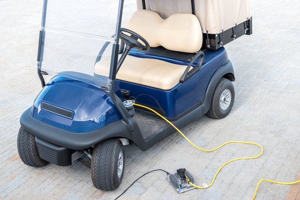 A Blue Golf Cart Is Being Charged with A Yellow Cord — Toukley World of Bikes In Toukley, NSW