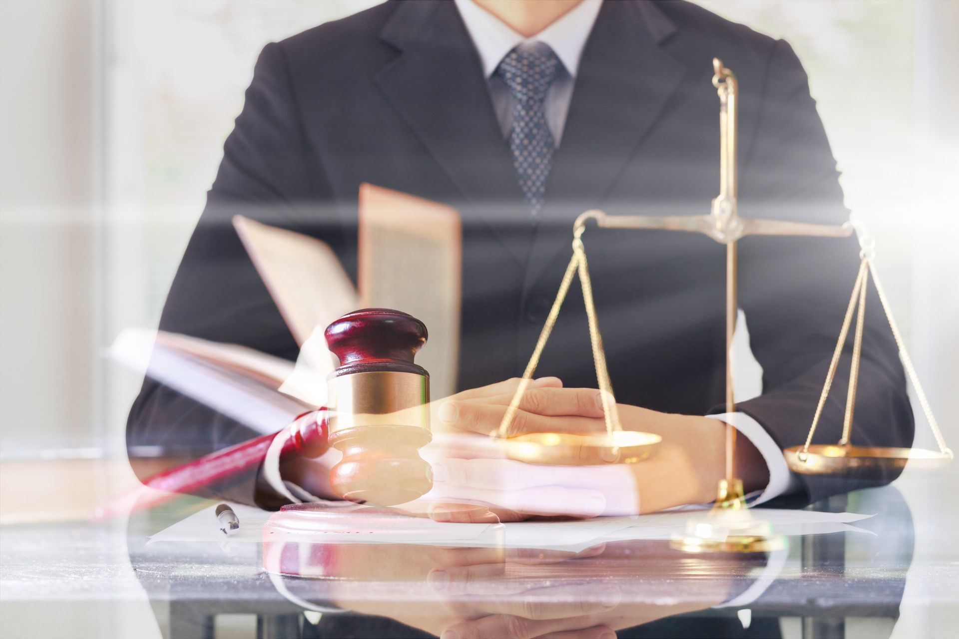 A person in a suit sits behind a desk with a gavel, law books, and scales of justice superimposed on the image.