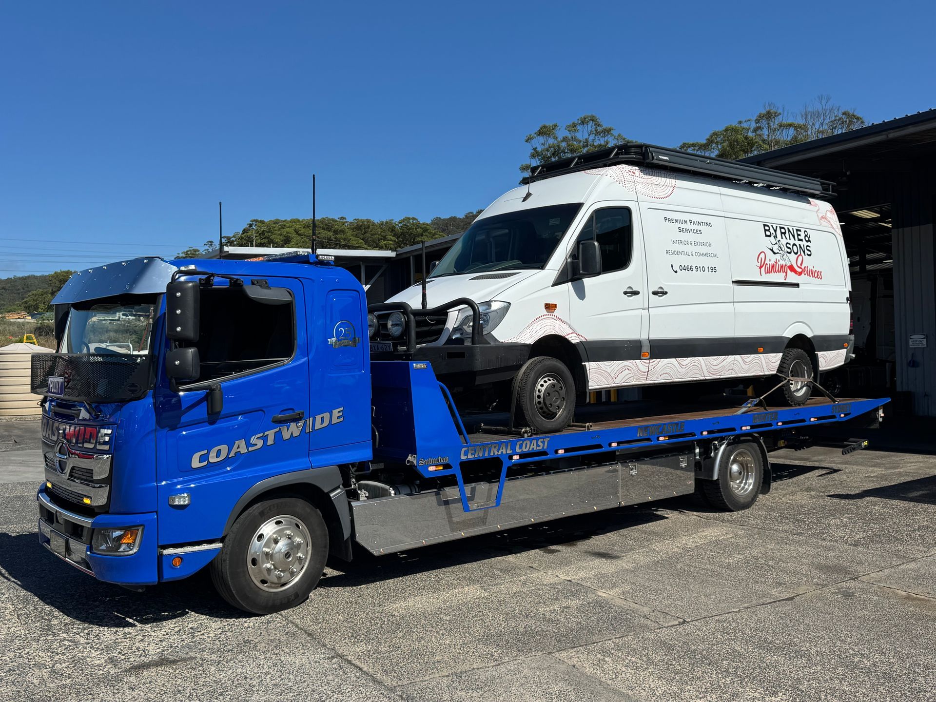 Blue Coastwork tow truck transporting a white van on a sunny day. — Coastwide Towing & Transport In Berkeley Vale, NSW