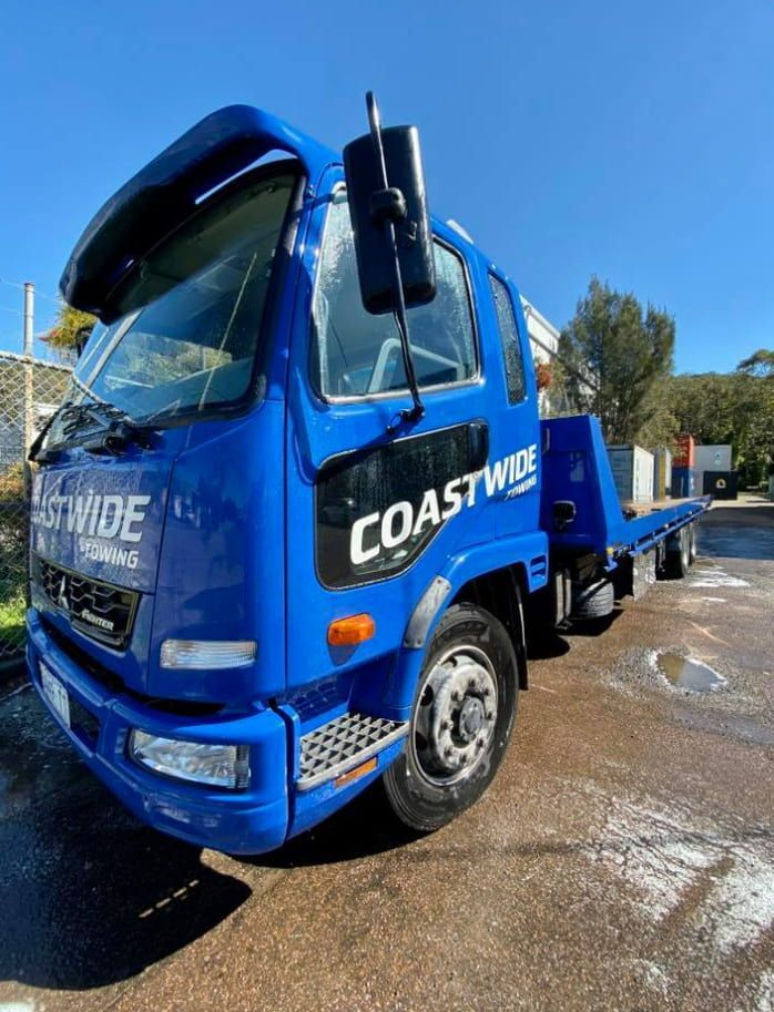 A Blue Coastwide Tow Truck Is Parked On The Side Of The Road — Coastwide Towing & Transport In Central Coast, NSW