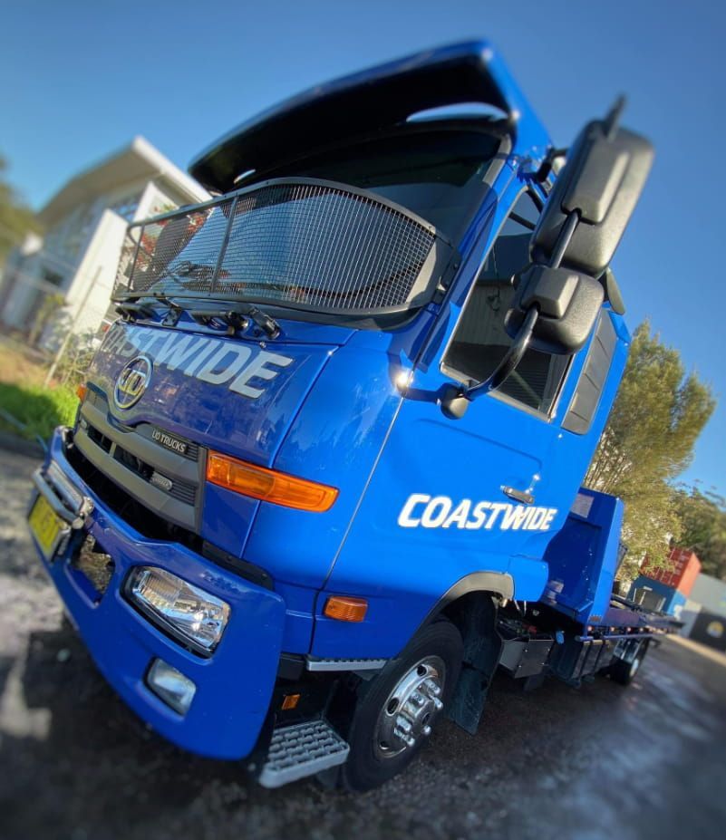 A Blue Coastwide Truck Is Parked On The Side Of The Road — Coastwide Towing & Transport In Cessnock, NSW