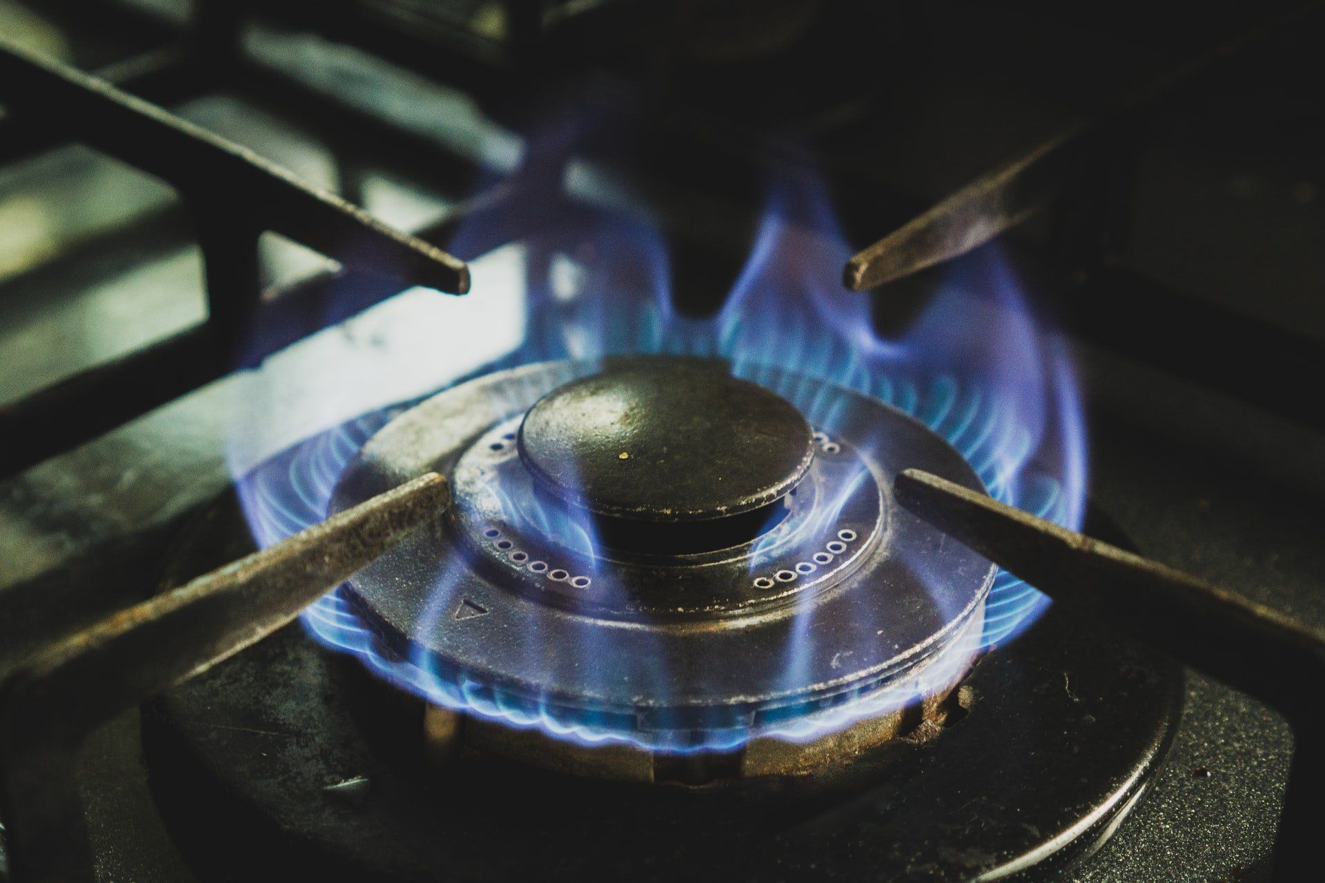 A burner on a natural gas stove producing a blue flame