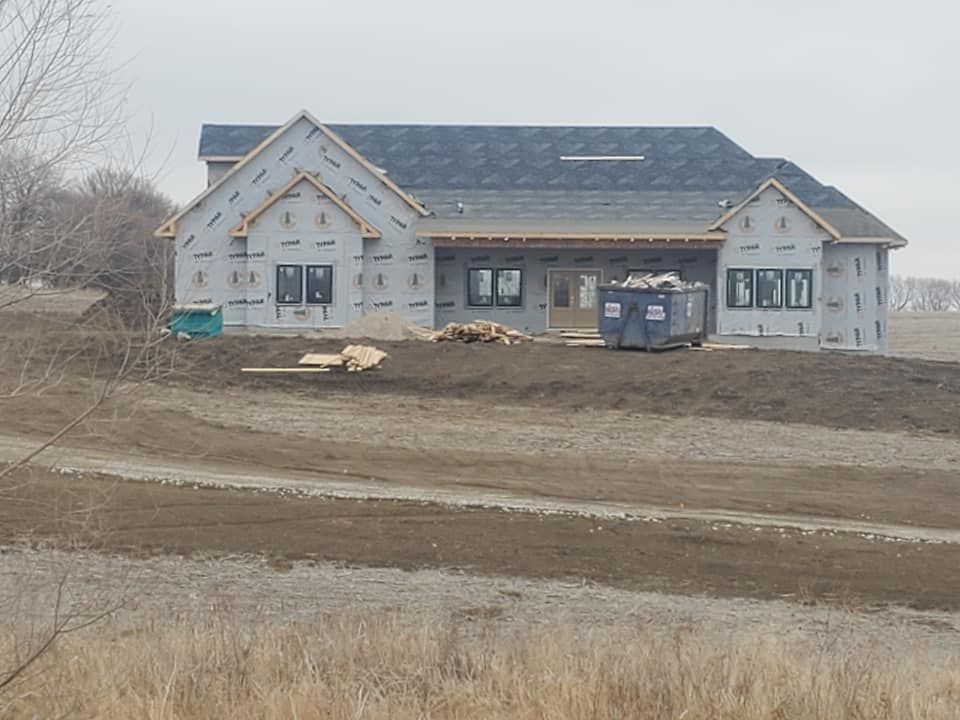 A large house is being built in the middle of a dirt field. Independence Built Custom Home Builder in Nebraska