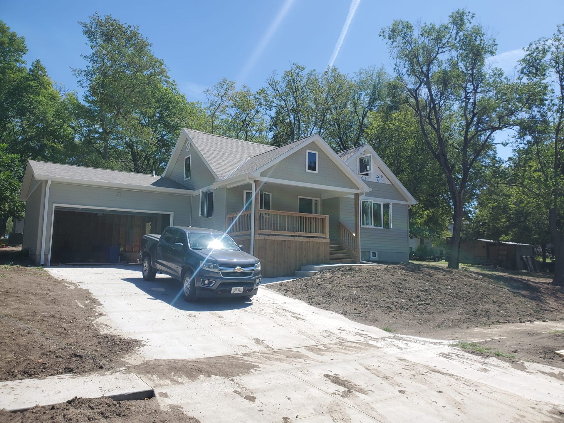 A car is parked in front of a house that is under construction